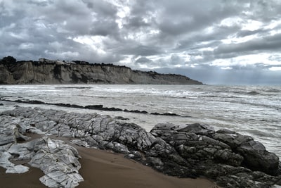 灰色岩石附近海下灰色的天空
